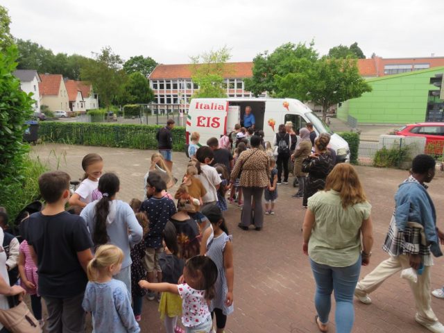 Kinder und Erwachsene stehen Schlange vor dem Eiswagen